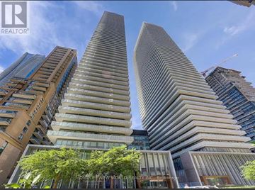 Toronto (Church-Yonge Corridor) condo for rent - Two tall buildings in a city with trees in the foreground.