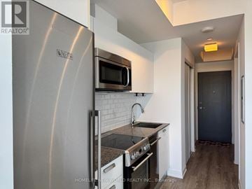 Toronto (Church-Yonge Corridor) condo for rent - A modern kitchen with a stainless steel refrigerator and microwave.
