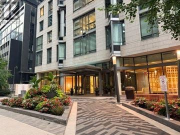 Toronto (Church-Yonge Corridor) condo for rent - The image shows a hotel entrance with a paved walkway and a variety of plants on either side.