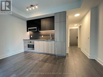 Toronto (Church-Yonge Corridor) condo for rent - A modern kitchen with a wooden floor and white walls.