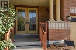Brampton (Snelgrove) apartment for rent - A home entrance with a glass door and a small table and chair set.