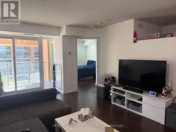 Toronto (Niagara) condo for rent - A living room with a grey couch and a black television.