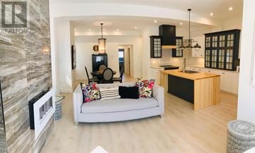 St.John's multi-family for rent - A modern living room with a grey sofa and a stone wall.