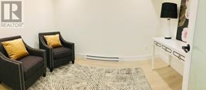 St.John's multi-family for rent - A living room with two chairs and a table with a lamp.