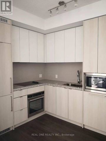 Toronto (Waterfront Communities) condo for rent - A kitchen with white cabinets and appliances.