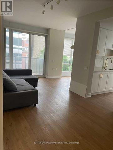 Toronto (Church-Yonge Corridor) condo for rent - A living room with a grey couch and wooden floors.
