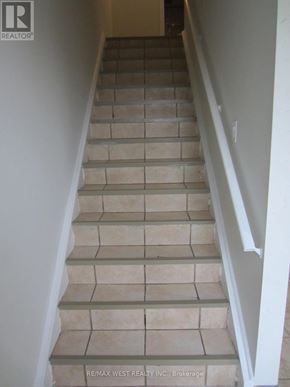 Toronto (Humber Summit) apartment for rent - A staircase with beige tiles and white railings.