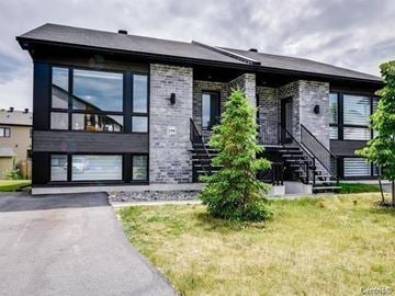 Gatineau (Aylmer) condo for rent - A modern house with a black roof and a stone facade.