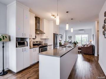 Gatineau (Aylmer) condo for rent - A kitchen with white cabinets and a wooden floor.