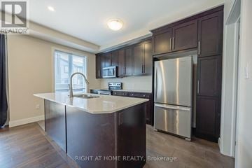 London North (North F) townhouse for rent - A kitchen with dark brown cabinets and a stainless steel refrigerator.
