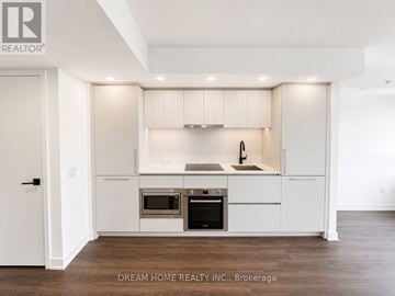 Toronto (North St. James Town) condo for rent - A modern kitchen with white cabinets and stainless steel appliances.