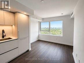 Toronto (North St. James Town) condo for rent - A well-lit kitchen with wooden floors and white cabinets.