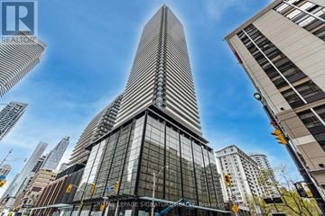 Toronto (Church-Yonge Corridor) condo for rent - A tall, modern building with a pointed top is the focal point of the image.