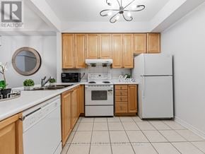 Toronto (Bendale) townhouse for rent - A kitchen with wooden cabinets and white appliances.