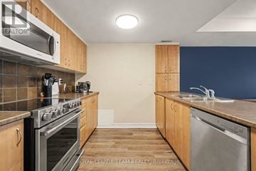 Ottawa townhouse for rent - A kitchen with wooden cabinets and stainless steel appliances.