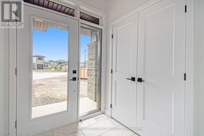 Arnprior townhouse for rent - A white door with a glass window is open to a backyard.