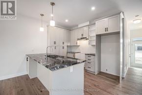 Arnprior townhouse for rent - A kitchen with a marble countertop and white cabinets.