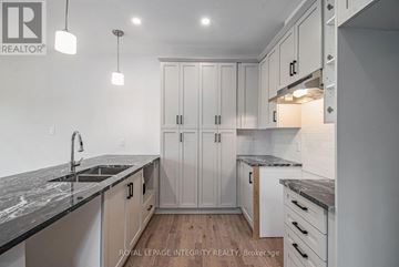 Arnprior townhouse for rent - A modern kitchen with white cabinets and a marble countertop.