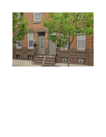 Philadelphia apartment for rent - A brown building with a grey door and steps leading up to it.