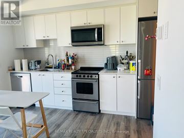 Waterloo condo for rent - A kitchen with white cabinets and a stainless steel refrigerator.
