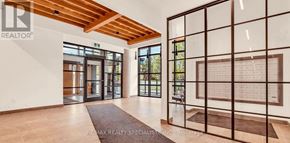 Waterloo condo for rent - A spacious room with a wooden ceiling and a large window.