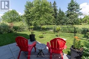 Huntsville (Chaffey) house for rent - A patio with a table and chairs is surrounded by a green fence.