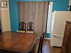 Sarnia apartment for rent - A kitchen with a white refrigerator and a wooden table.