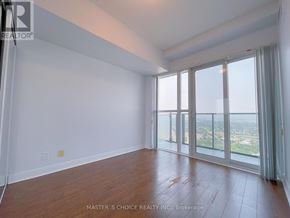 Mississauga (City Centre) condo for rent - A room with wooden floors and sliding glass doors leading to a balcony.