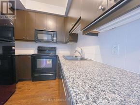 Mississauga (City Centre) condo for rent - A kitchen with black appliances and a granite countertop.
