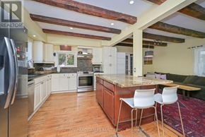 Caledon (Cheltenham) apartment for rent - A kitchen with a refrigerator on the left and a table with two chairs in the middle.