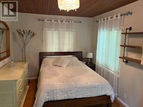 Caledon (Cheltenham) apartment for rent - A bedroom with a bed, nightstand, and a chandelier.