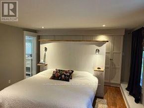 Caledon (Cheltenham) apartment for rent - A bedroom with a bed, nightstand, and lamp.