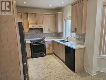Mississauga (Churchill Meadows) apartment for rent - A kitchen with wooden cabinets and black appliances.