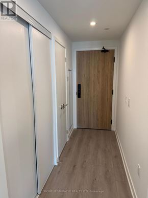 Mississauga (Mississauga Valleys) condo for rent - A hallway with a wooden door and white walls.