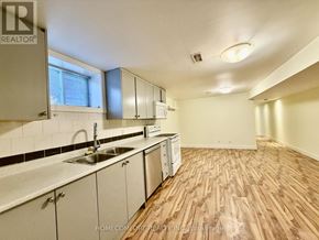 Toronto (Corso Italia-Davenport) multi-family for rent - A kitchen with wooden floors and white cabinets.