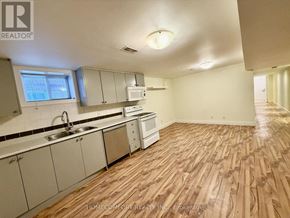 Toronto (Corso Italia-Davenport) multi-family for rent - A kitchen with wooden floors and white cabinets.