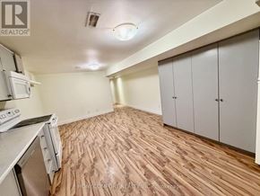 Toronto (Corso Italia-Davenport) multi-family for rent - A kitchen with wooden flooring and white appliances.