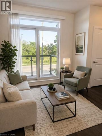Stoney Creek townhouse for rent - A living room with a couch, chair, and a table with a book on it.