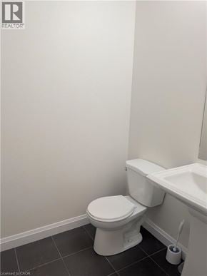 Stoney Creek townhouse for rent - A white toilet in a bathroom with a white sink.