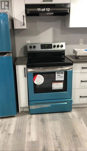 Kitchener apartment for rent - A blue refrigerator is next to a stove in a kitchen.