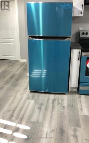 Kitchener apartment for rent - A blue fridge in a kitchen with wooden flooring.