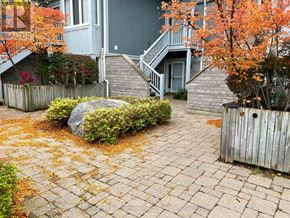 Collingwood condo for rent - A grey house with a stone pathway leading to the front door.