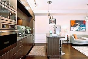Toronto (Willowdale East) condo for rent - A modern kitchen with dark wood cabinets and a marble island.
