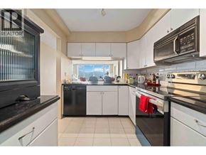 Burnaby apartment for rent - A kitchen with white cabinets and black appliances.