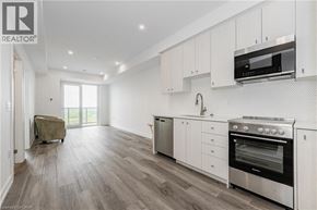 Kitchener condo for rent - A modern kitchen with white cabinets and stainless steel appliances.