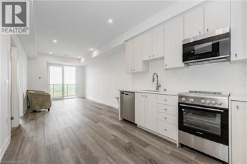 Kitchener condo for rent - A modern kitchen with white cabinets and stainless steel appliances.