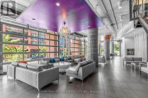 Toronto (Niagara) condo for rent - A modern living room with a purple ceiling light and a staircase on the right.
