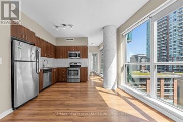 Toronto (Niagara) condo for rent - A modern kitchen with wooden cabinets and stainless steel appliances.