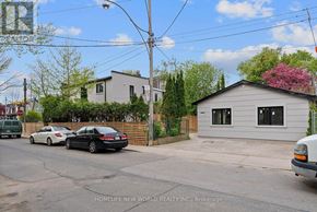 Toronto (Greenwood-Coxwell) apartment for rent - A street view with cars parked on the side of the road and houses in the background.