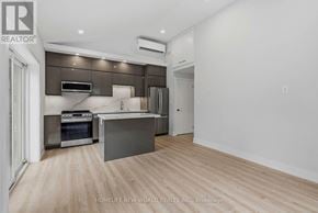 Toronto (Greenwood-Coxwell) apartment for rent - A modern kitchen with wooden floors and a large island.